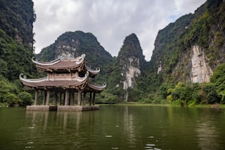 A building sitting on top of a lake surrounded by mountains