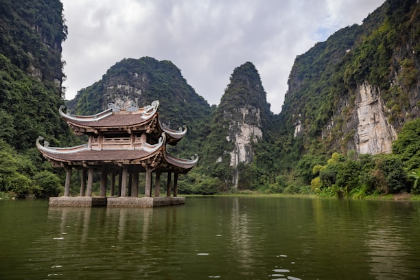 A building sitting on top of a lake surrounded by mountains