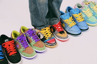 A row of different colored sneakers on a white surface