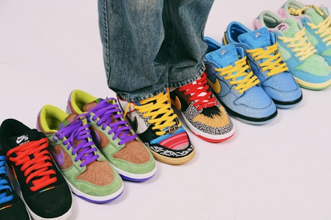A row of different colored sneakers on a white surface