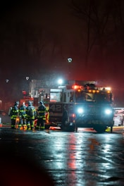 A group of firefighters standing next to a fire truck