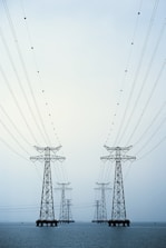 A couple of power lines sitting over a body of water