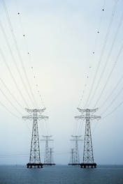 A couple of power lines sitting over a body of water