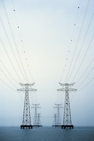 A couple of power lines sitting over a body of water