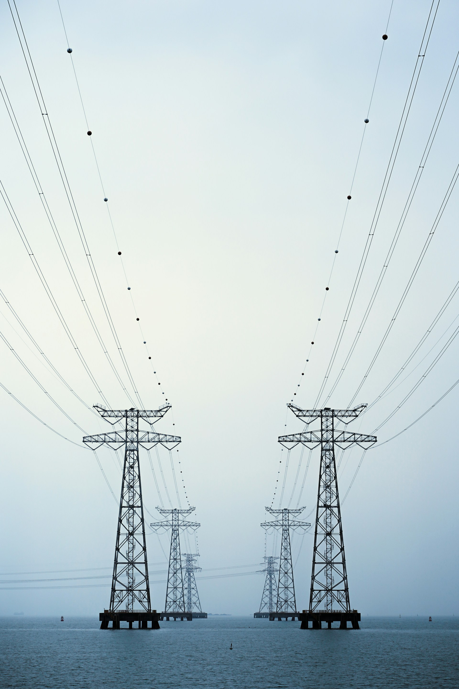 A couple of power lines sitting over a body of water