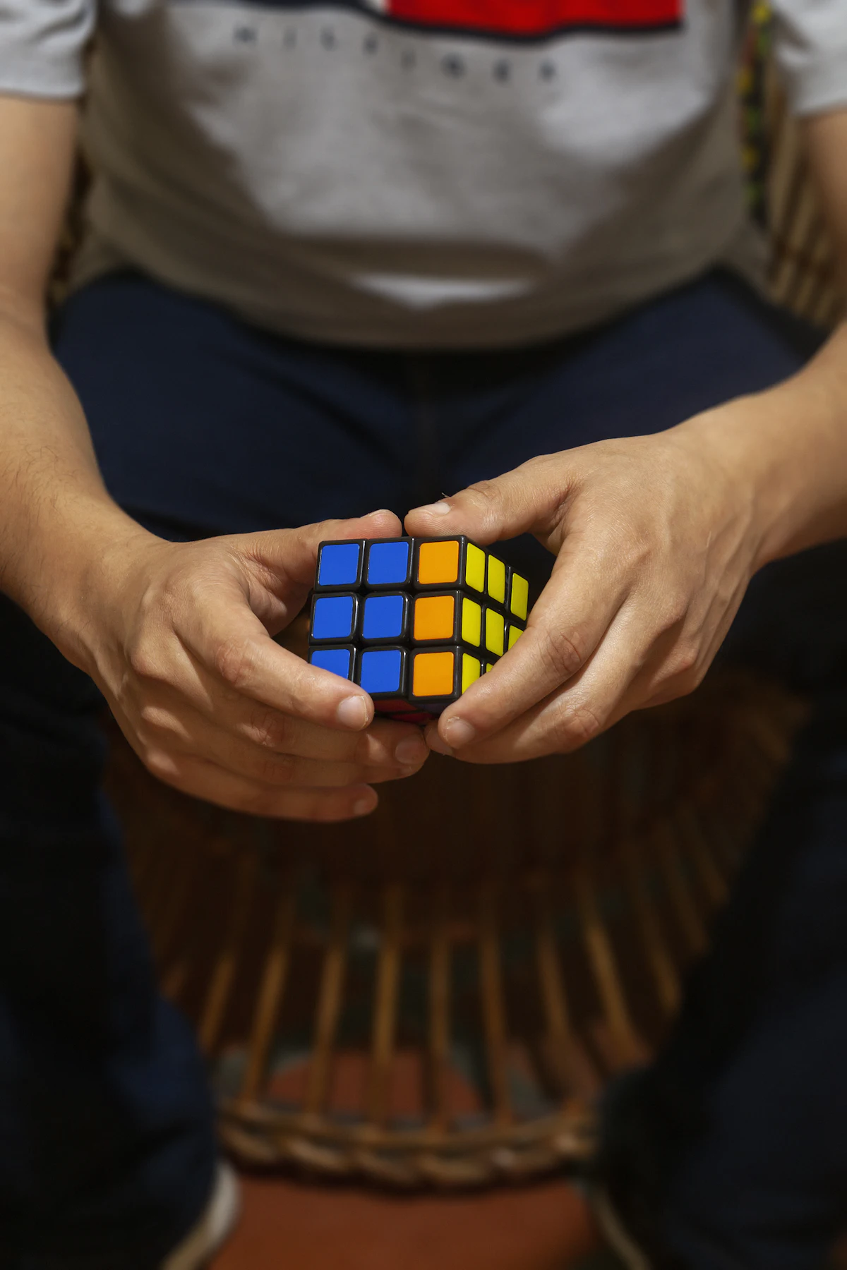 Hands holding a colorful Rubik's cube mid-solve, illustrating focused practice and pattern recognition