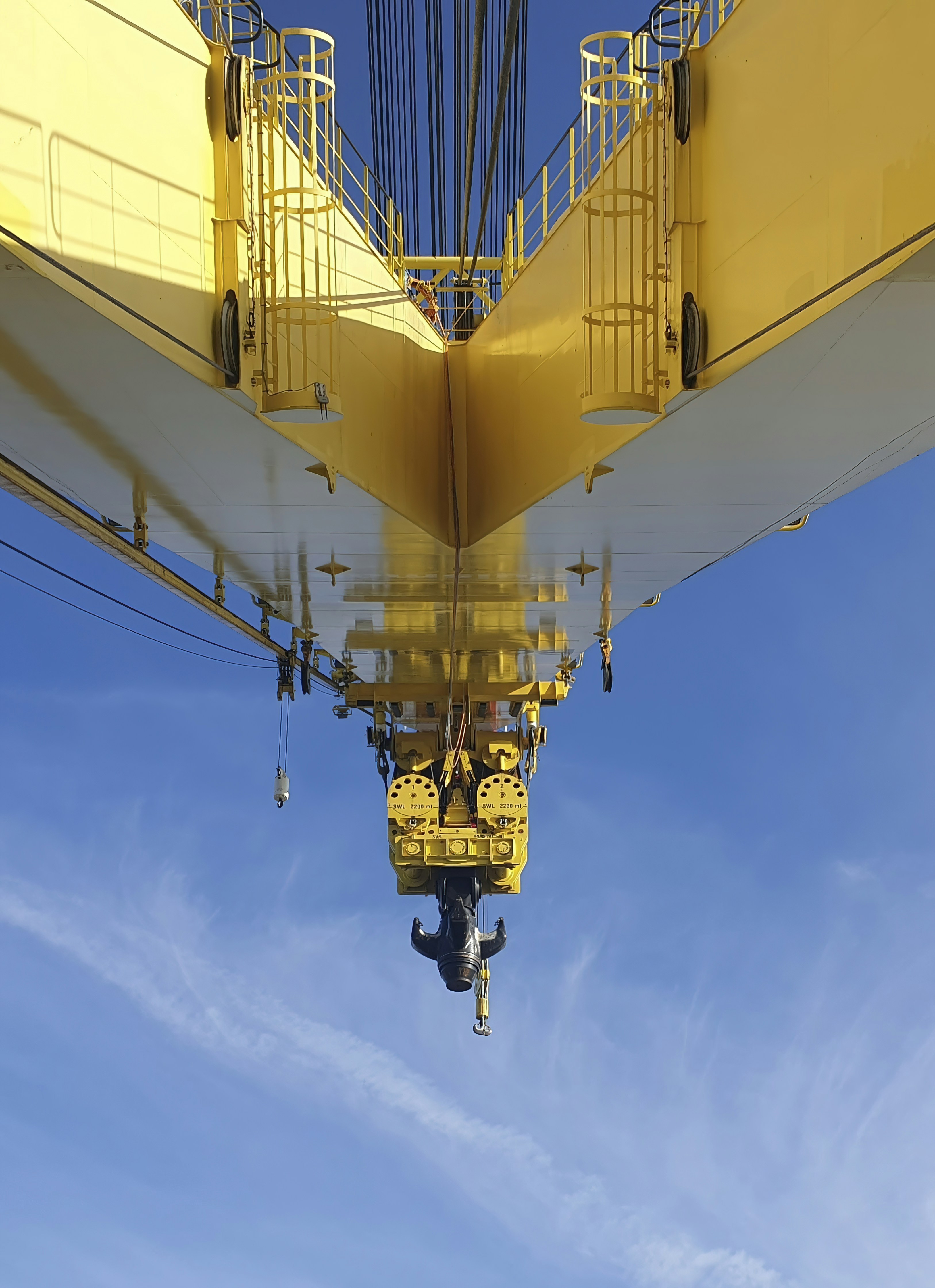 A crane is lifting a beam into the air