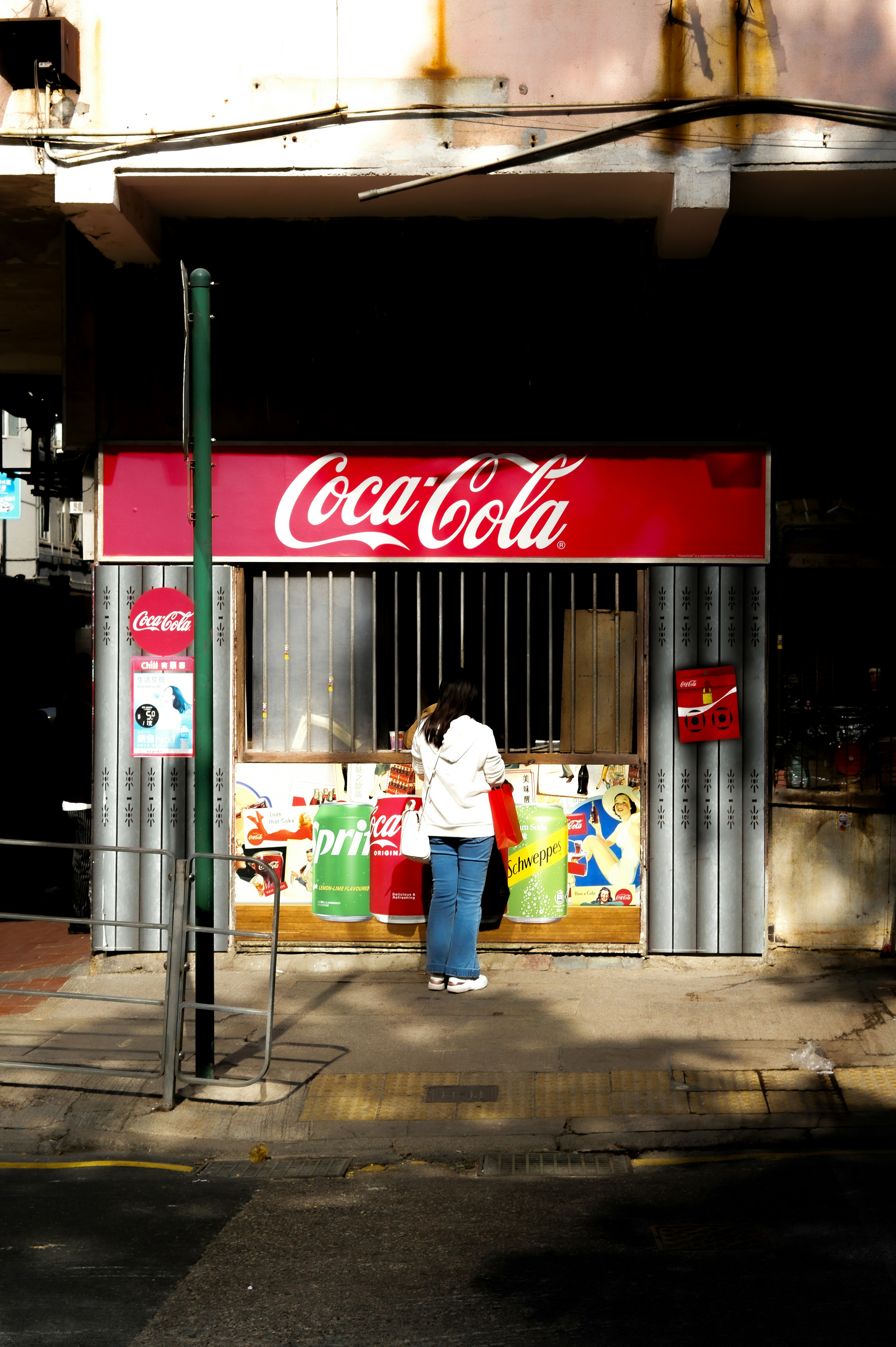 A woman standing in front of a coca cola store photo – Free Woman Image ...