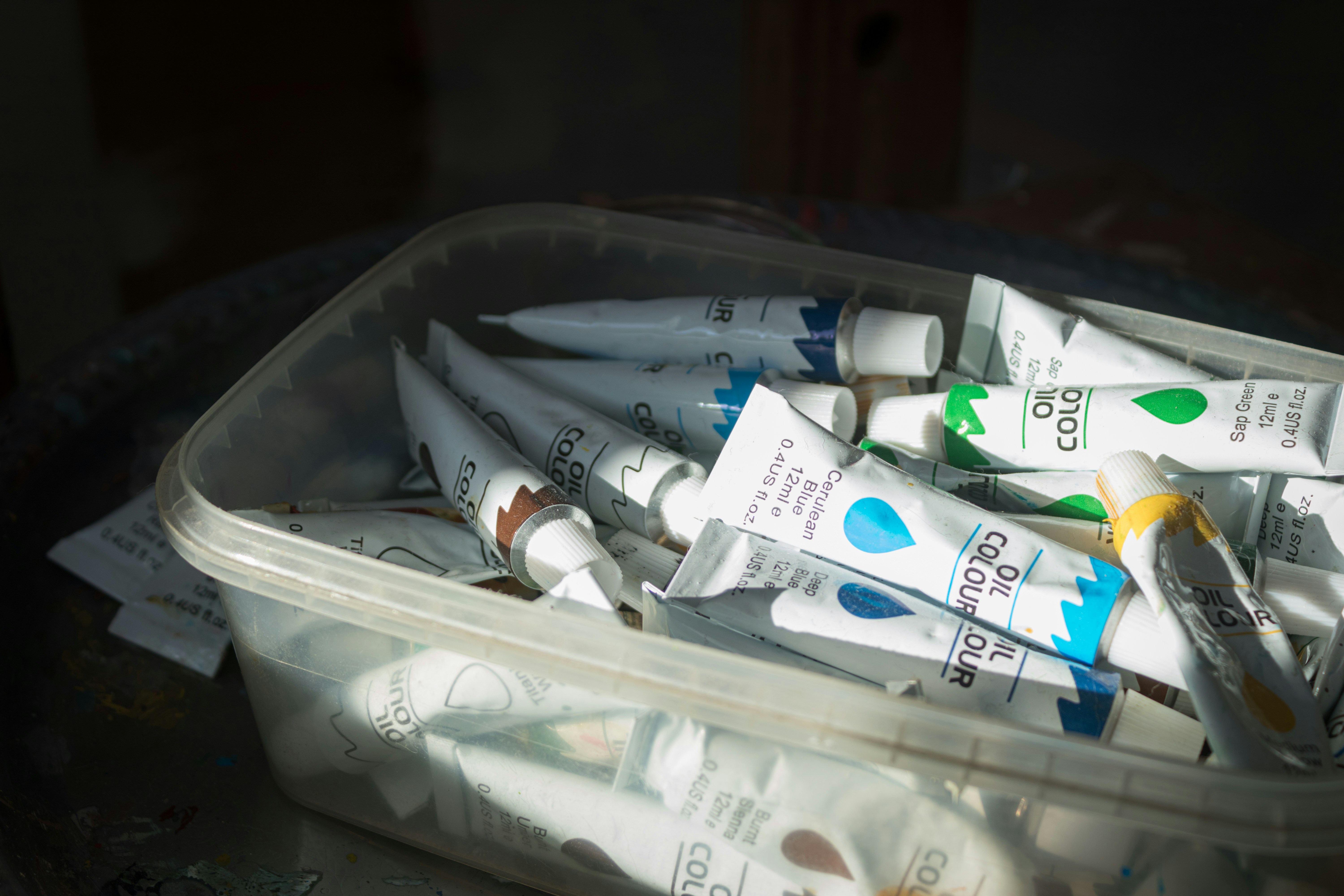 A plastic container filled with toothpaste and toothbrushes