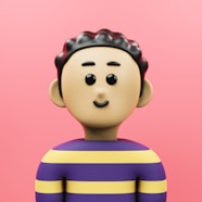 A small toy is standing in front of a pink background