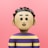 A small toy is standing in front of a pink background