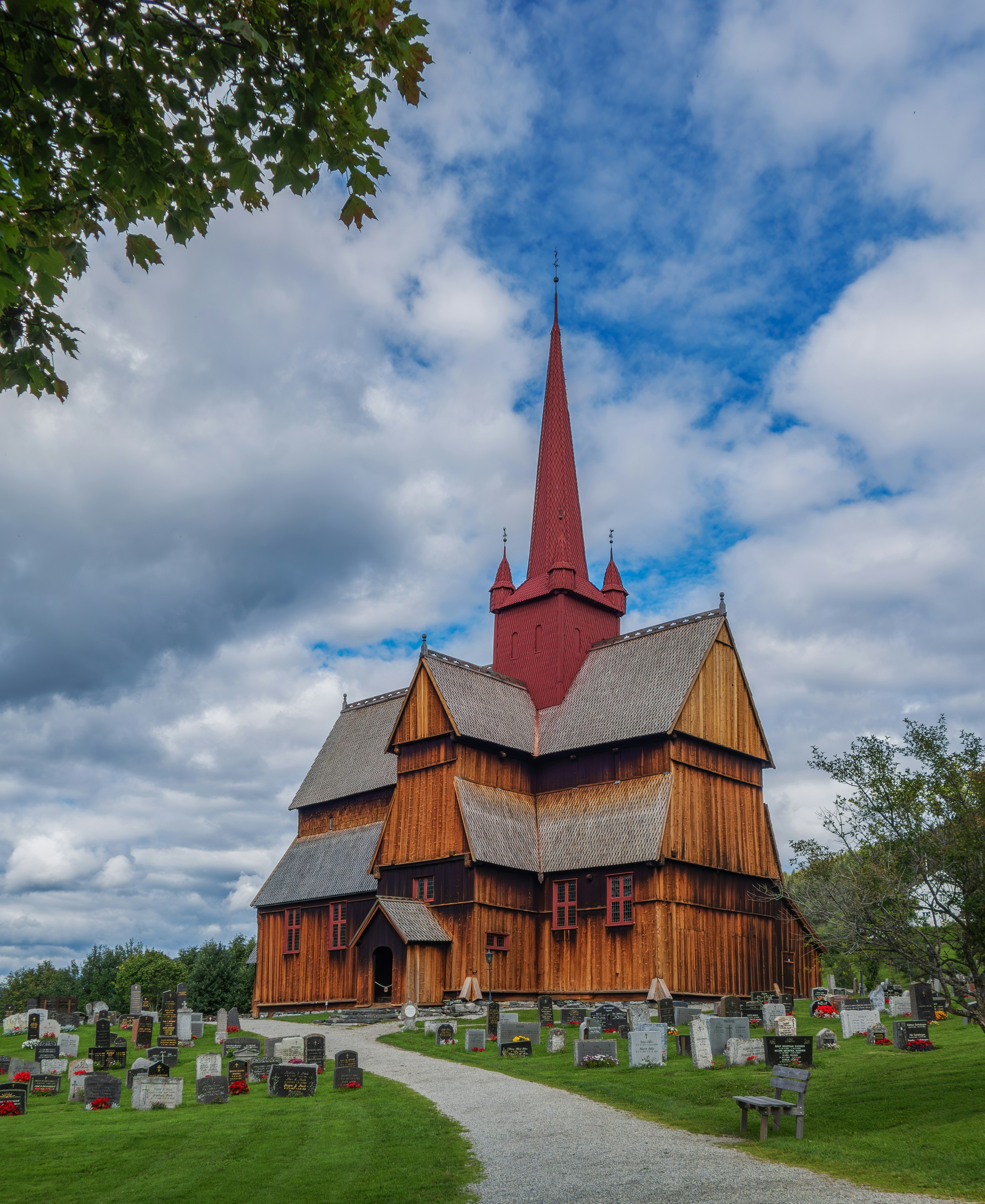 Une grande église en bois avec un clocher par temps nuageux