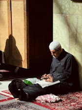 A man sitting on the floor with a book