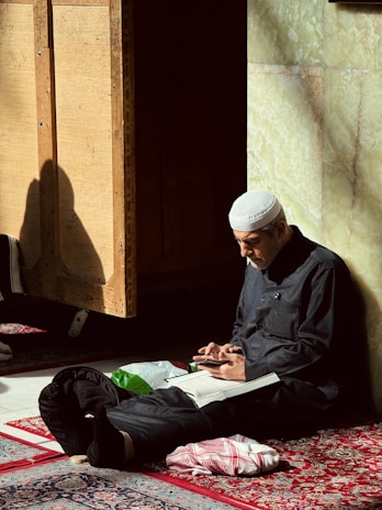 A man sitting on the floor with a book