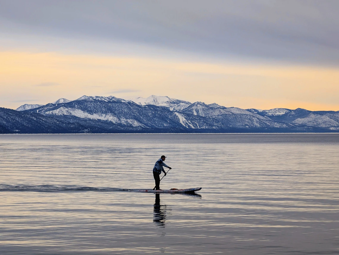 Paddleboarder exploring clear lake water in the open air