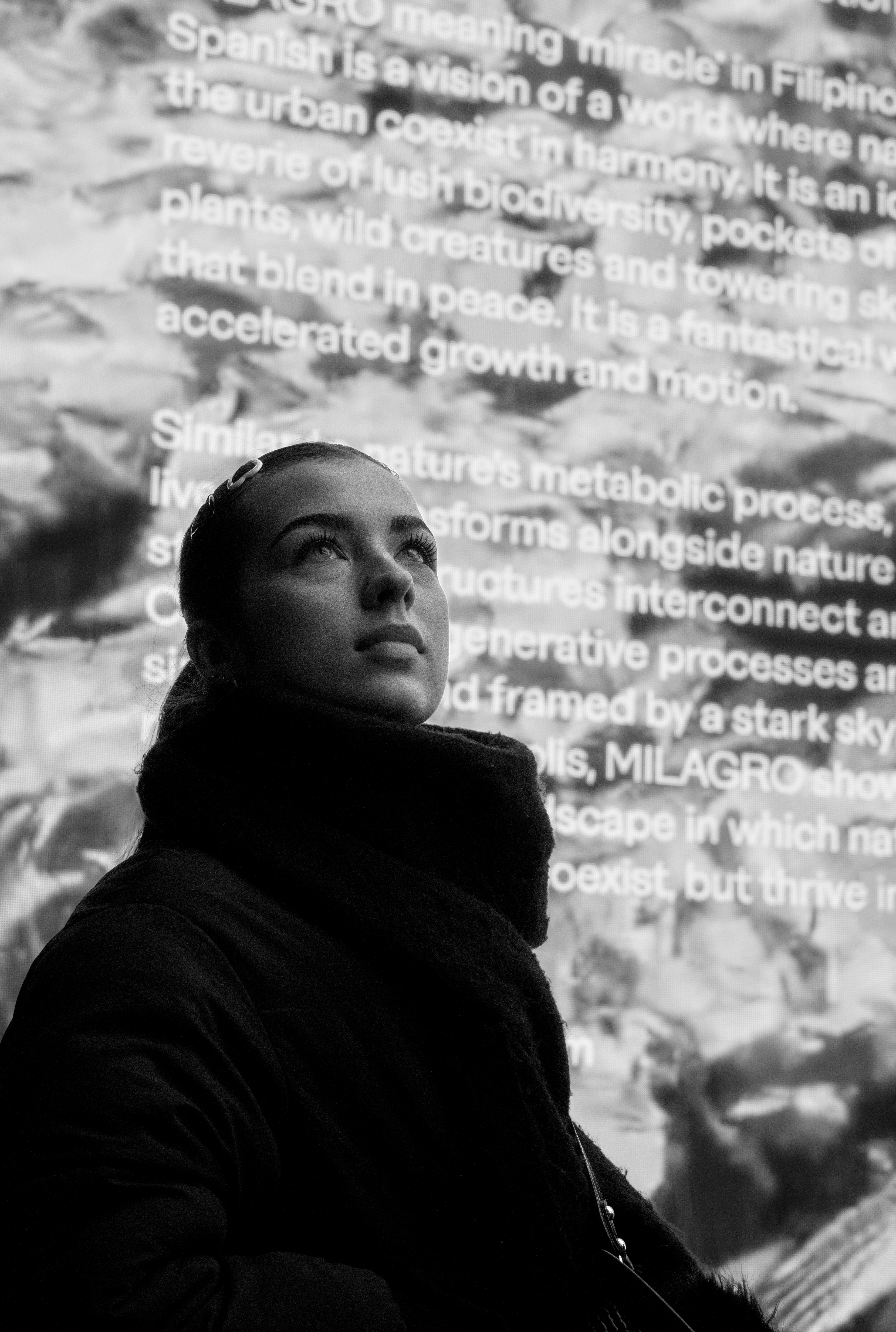 Une femme debout devant un mur avec des mots dessus