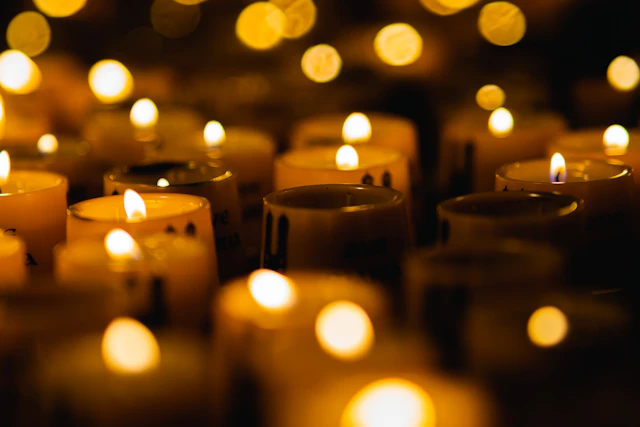Many small candles burning in the dark