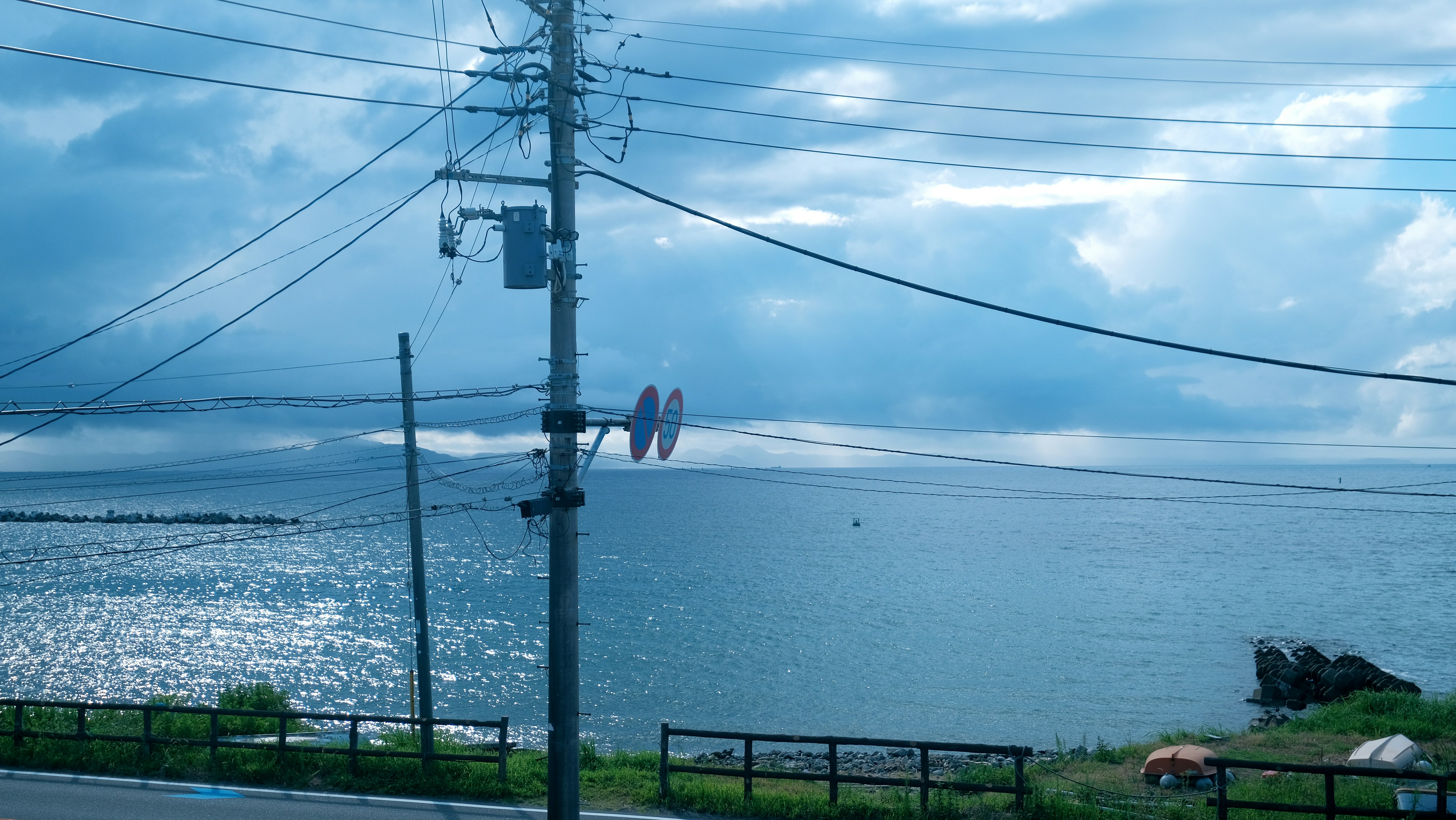 A view of a body of water with power lines in the foreground
