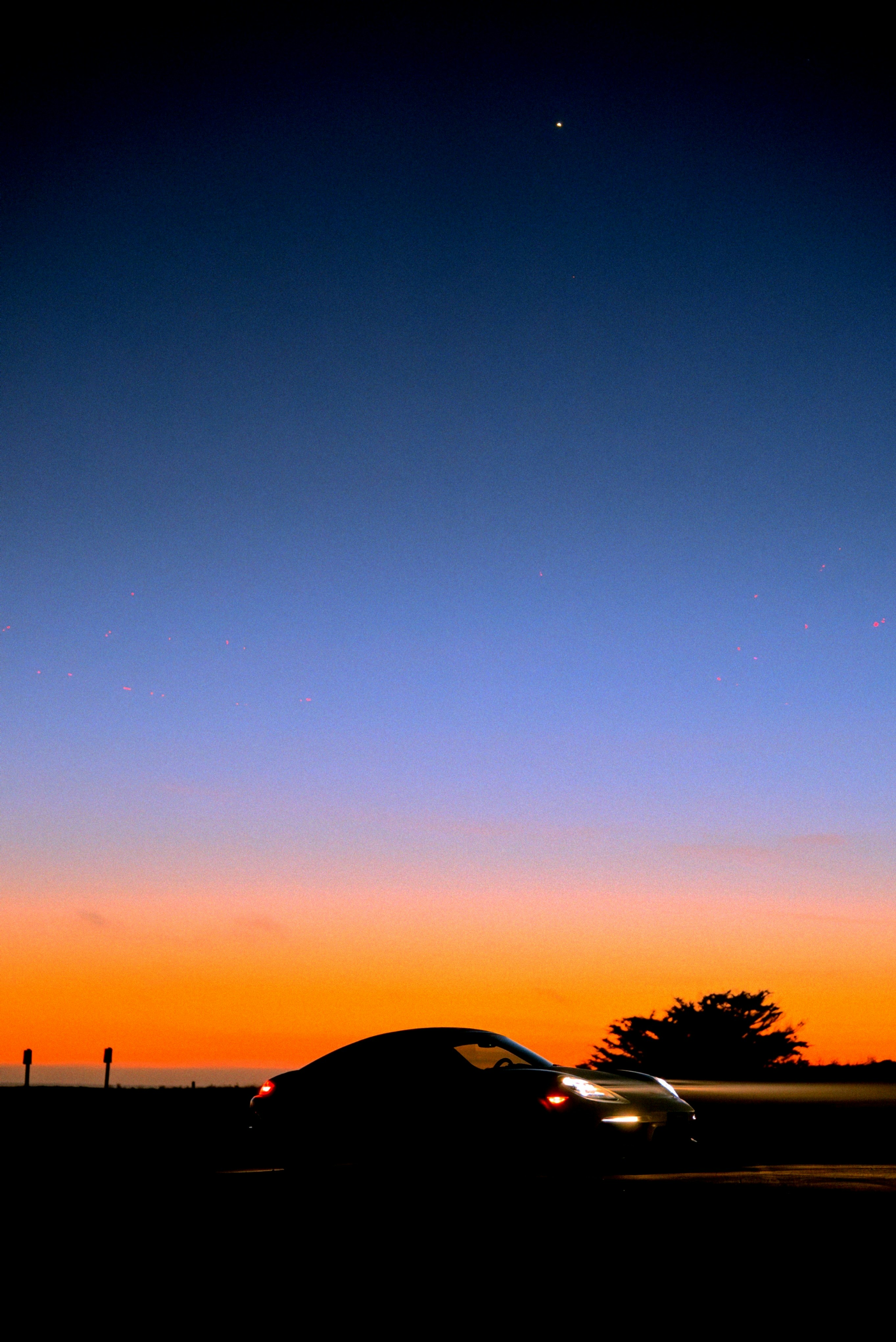 A car driving down a road at sunset