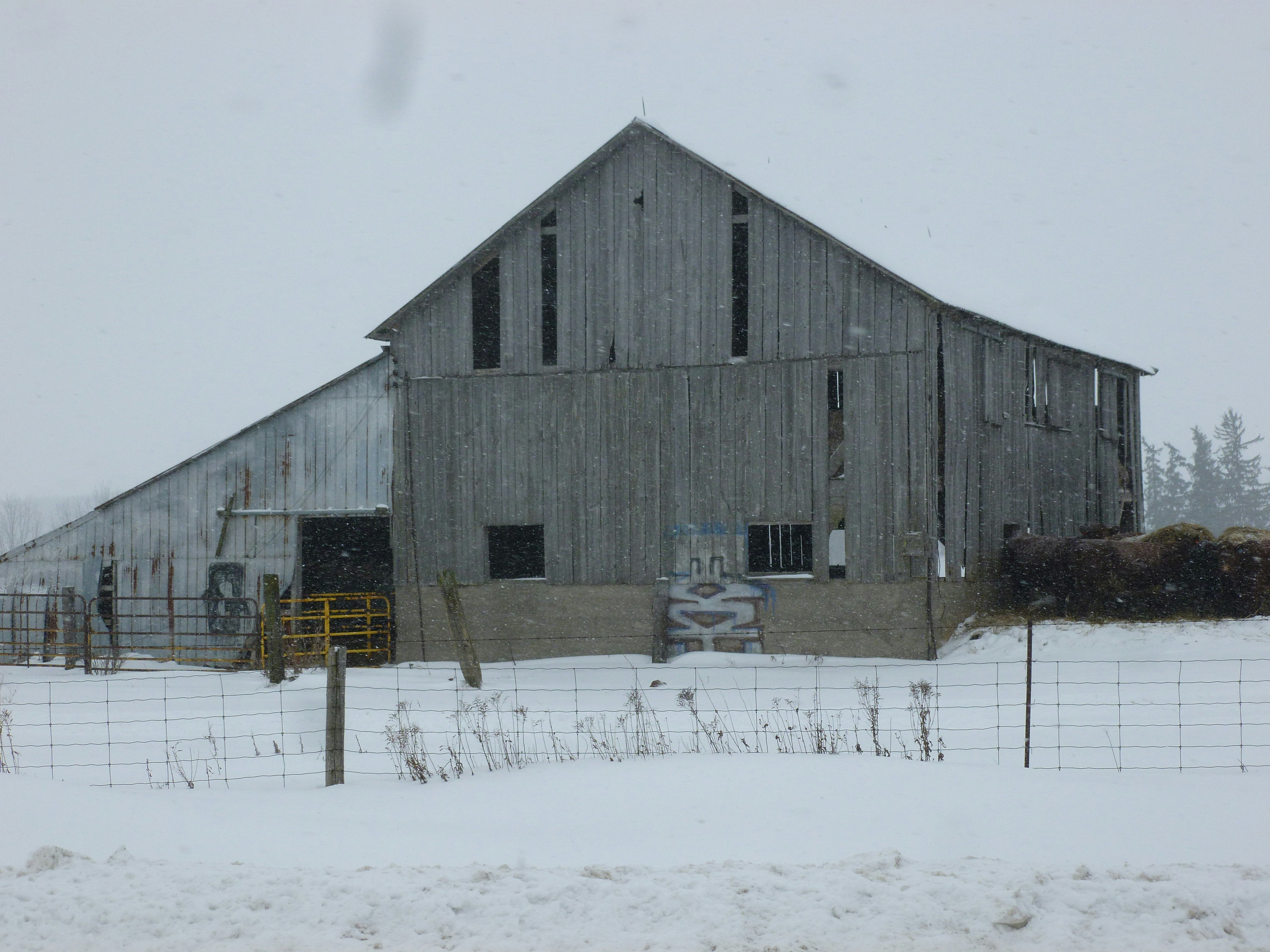 A barn in the middle of a snowy field