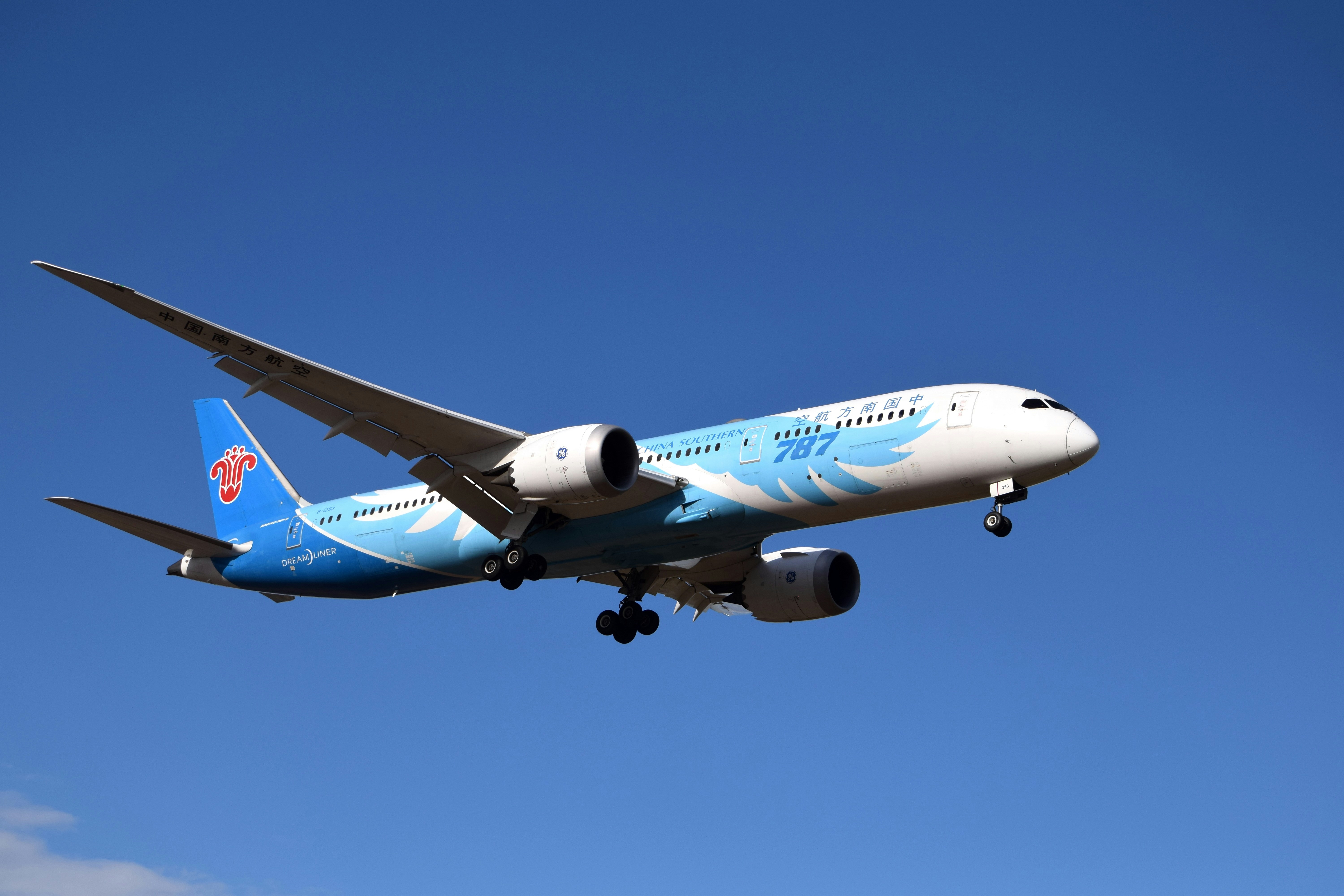 A blue and white airplane flying in the sky, 
