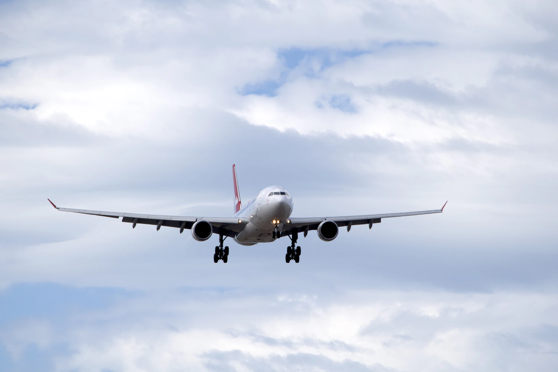 A large jetliner flying through a cloudy blue sky