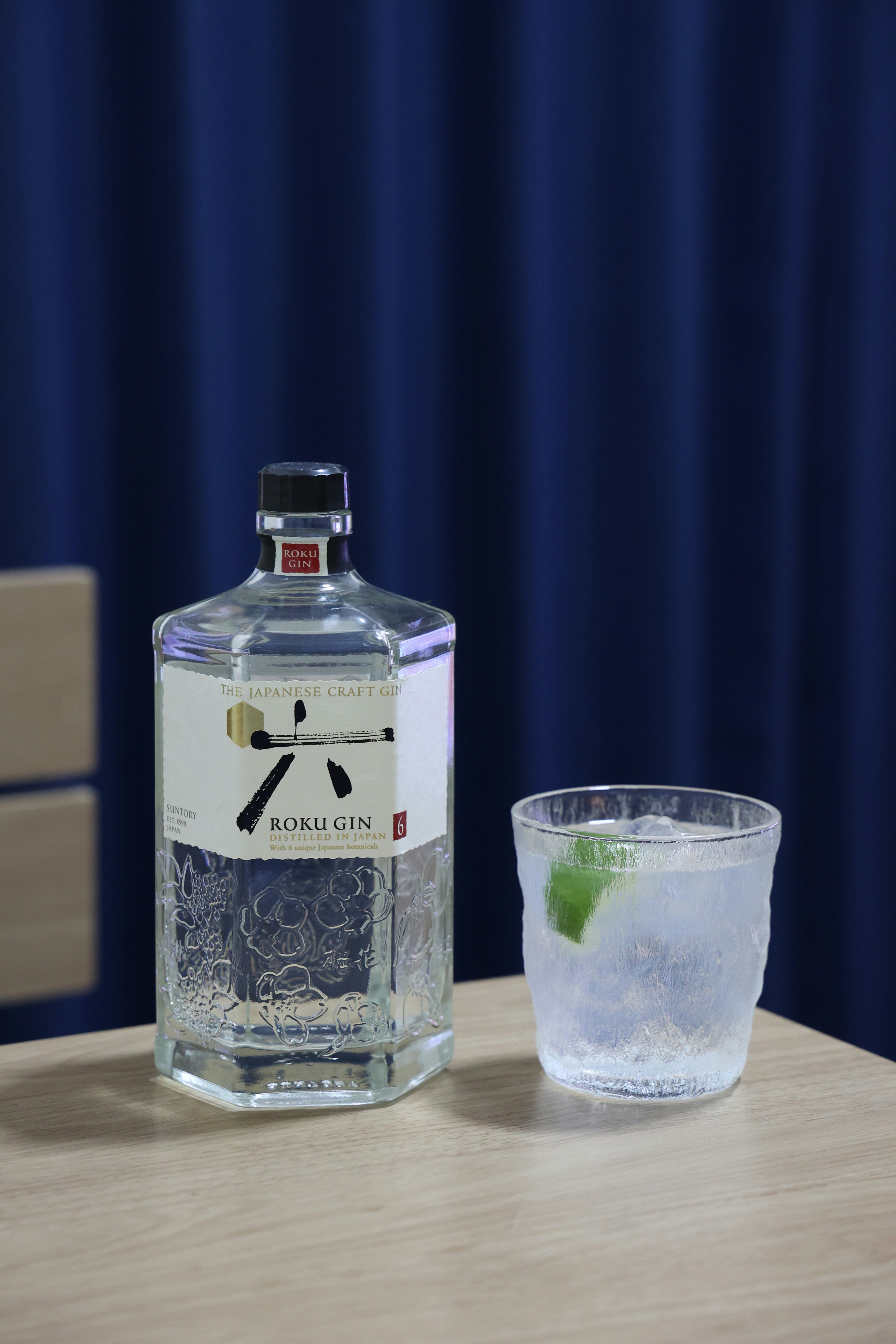 A bottle of gin and a glass on a table