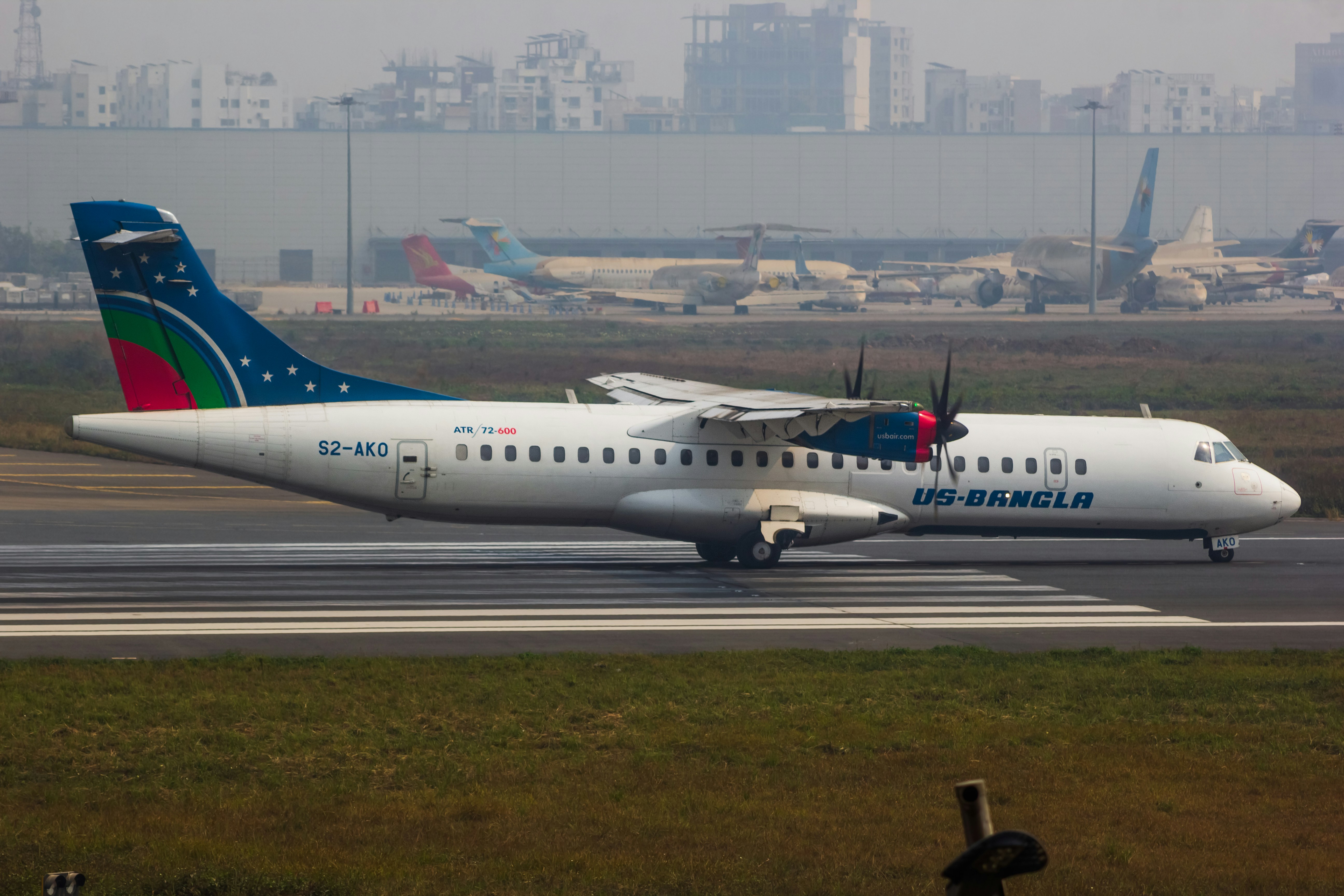 A large jetliner sitting on top of an airport runway, US-Bangla Airlines - ATR 72-600