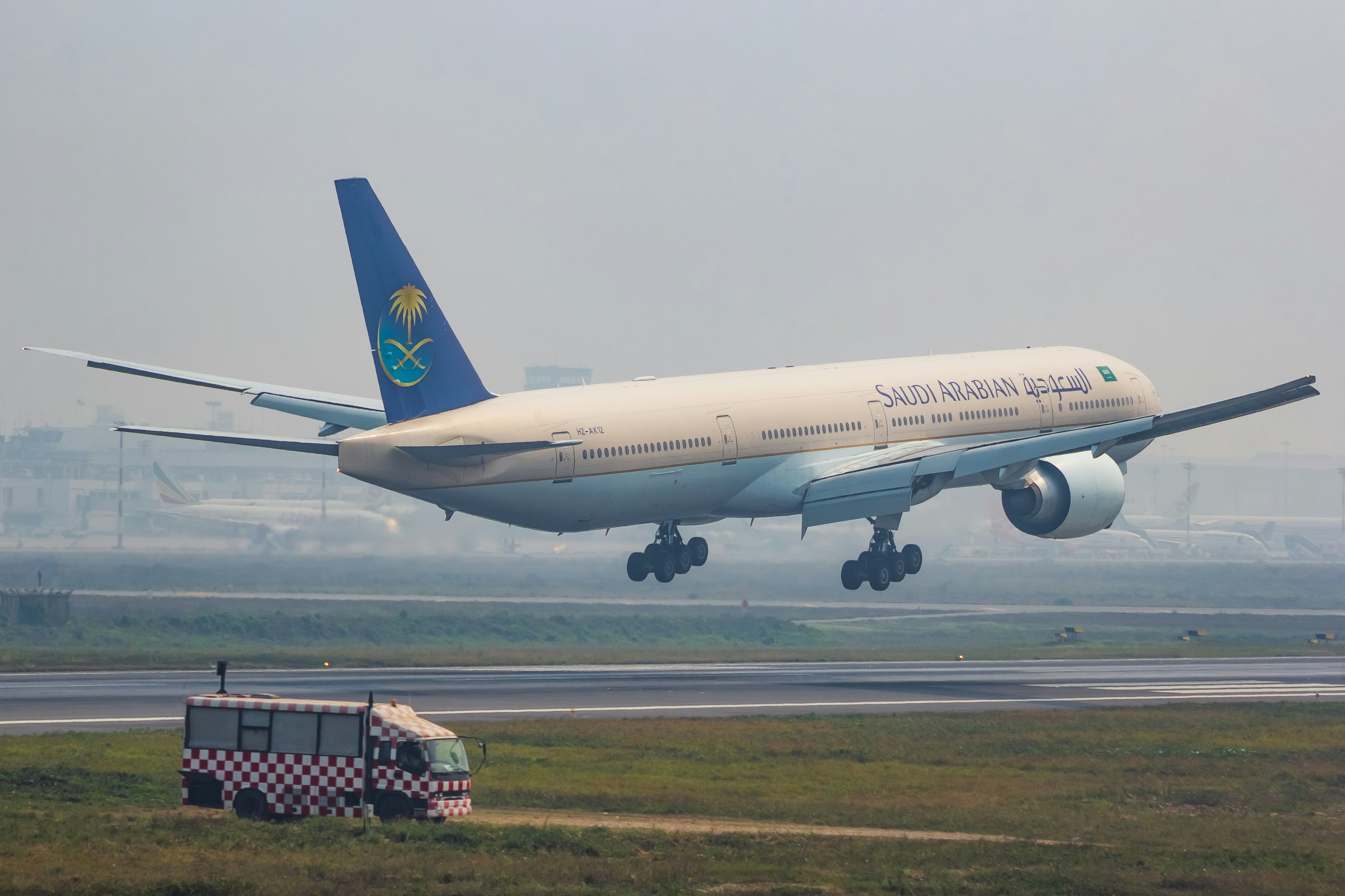 A large jetliner taking off from an airport runway, Saudia - Boeing 777-300ER