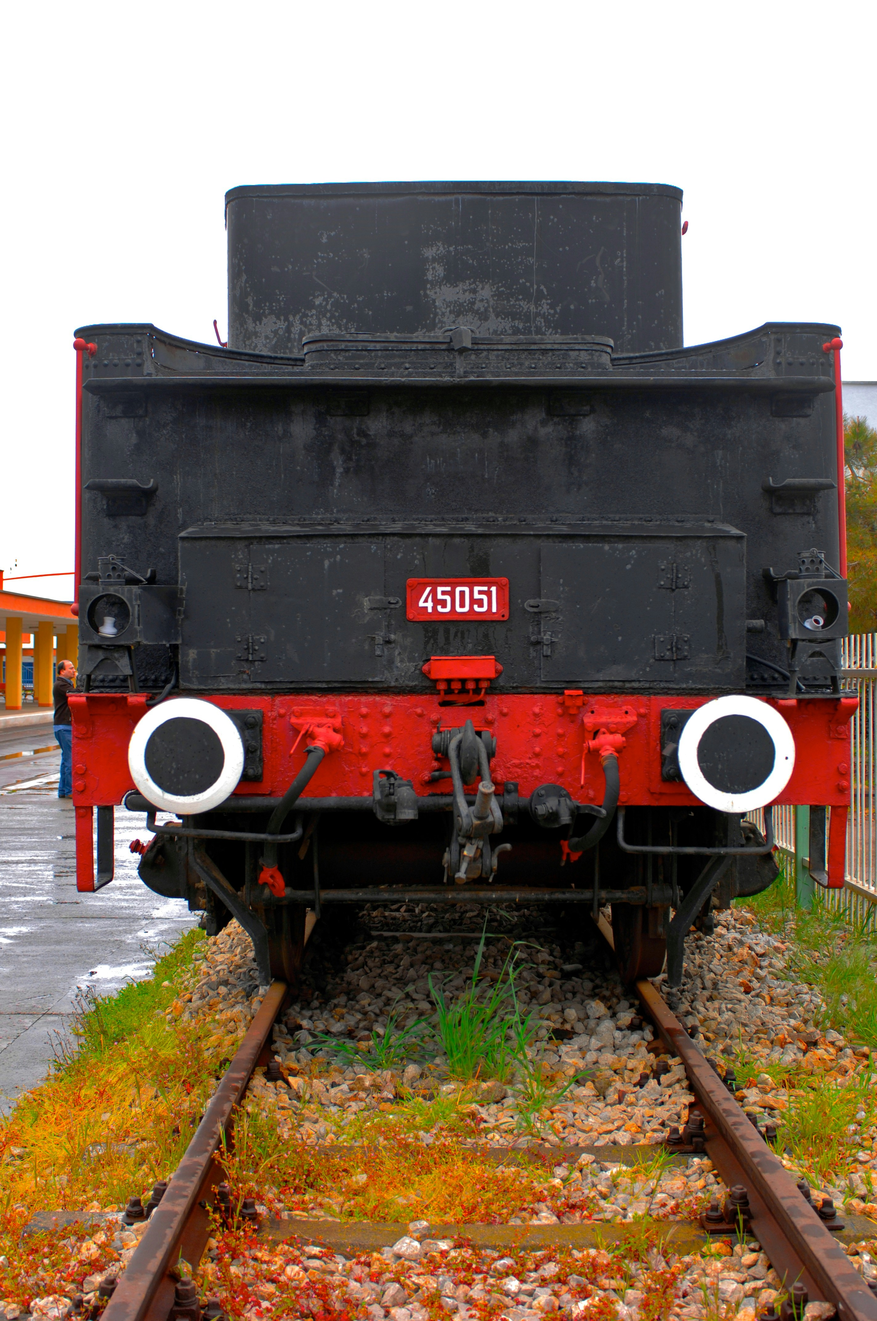 A black and red train sitting on top of train tracks