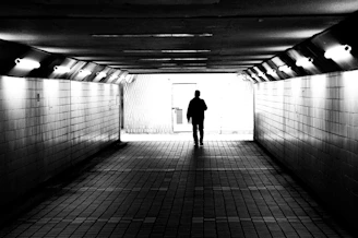 A man is standing in a dark tunnel