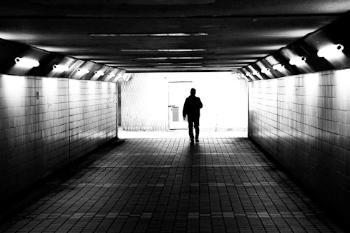 A man is standing in a dark tunnel