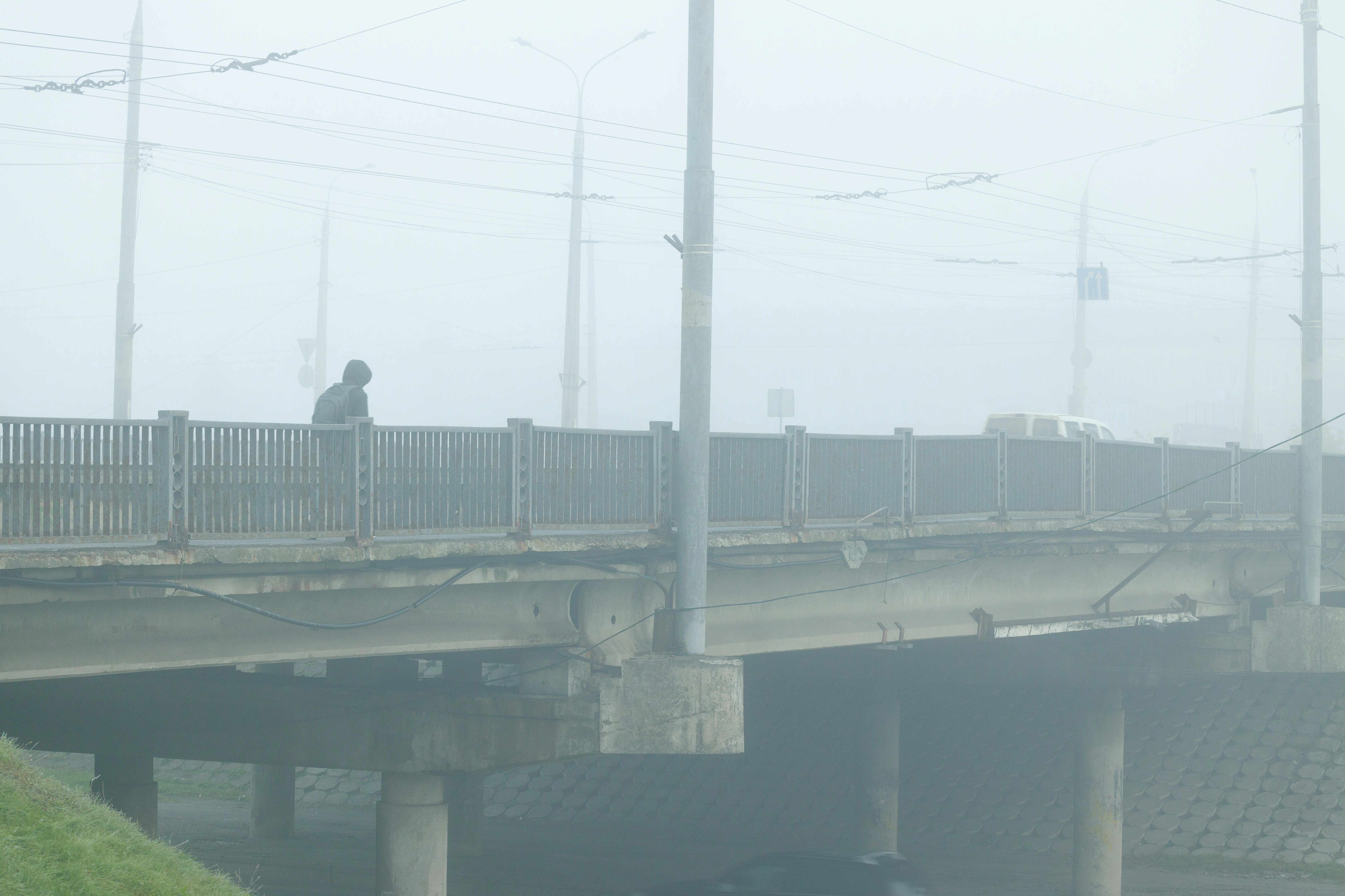 ugly poor Eastern Europe city scape element concrete bridge frame work pattern above car road with pillars in mist smoky weather polluted landmark urban environment space