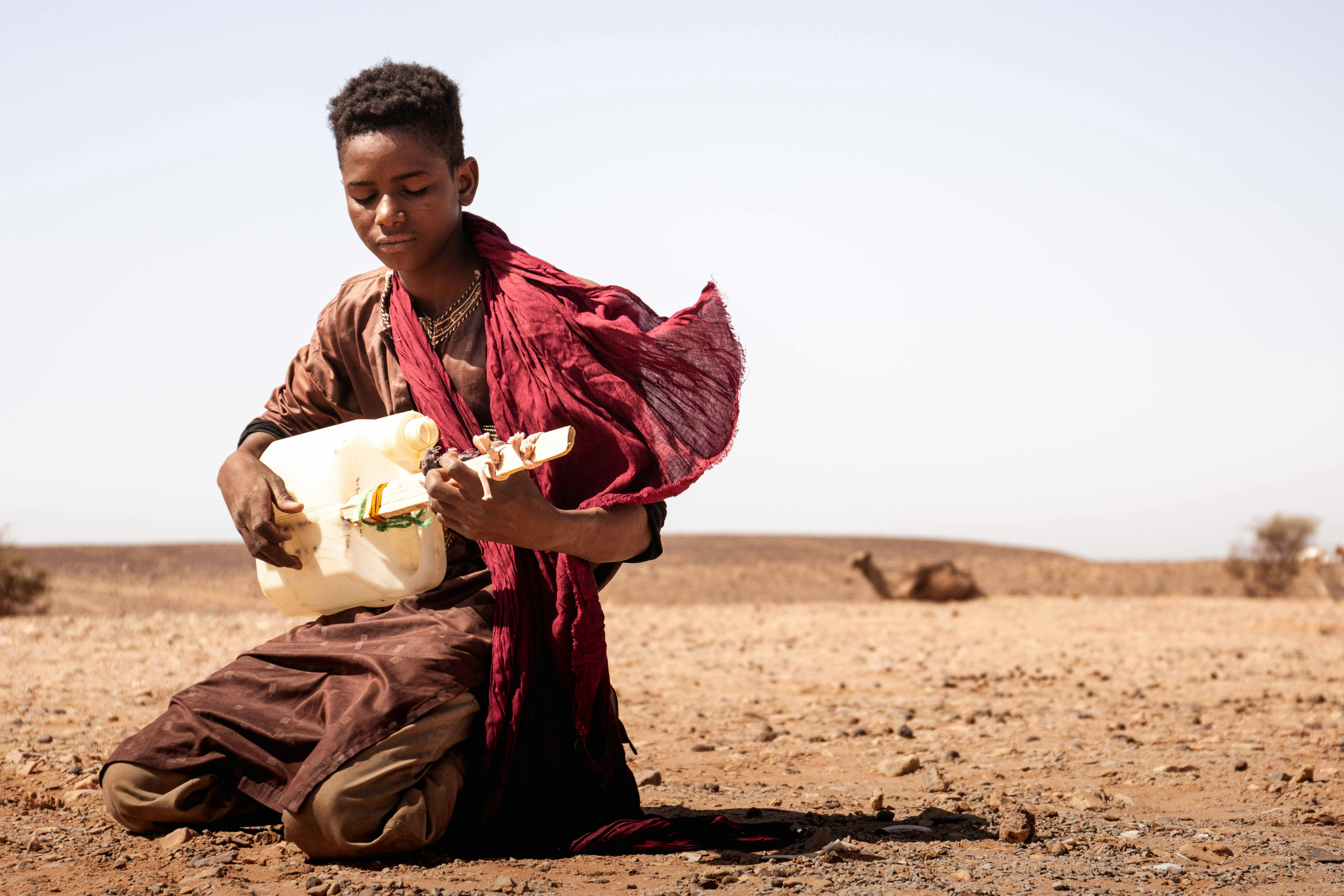 A man sitting in the middle of a desert