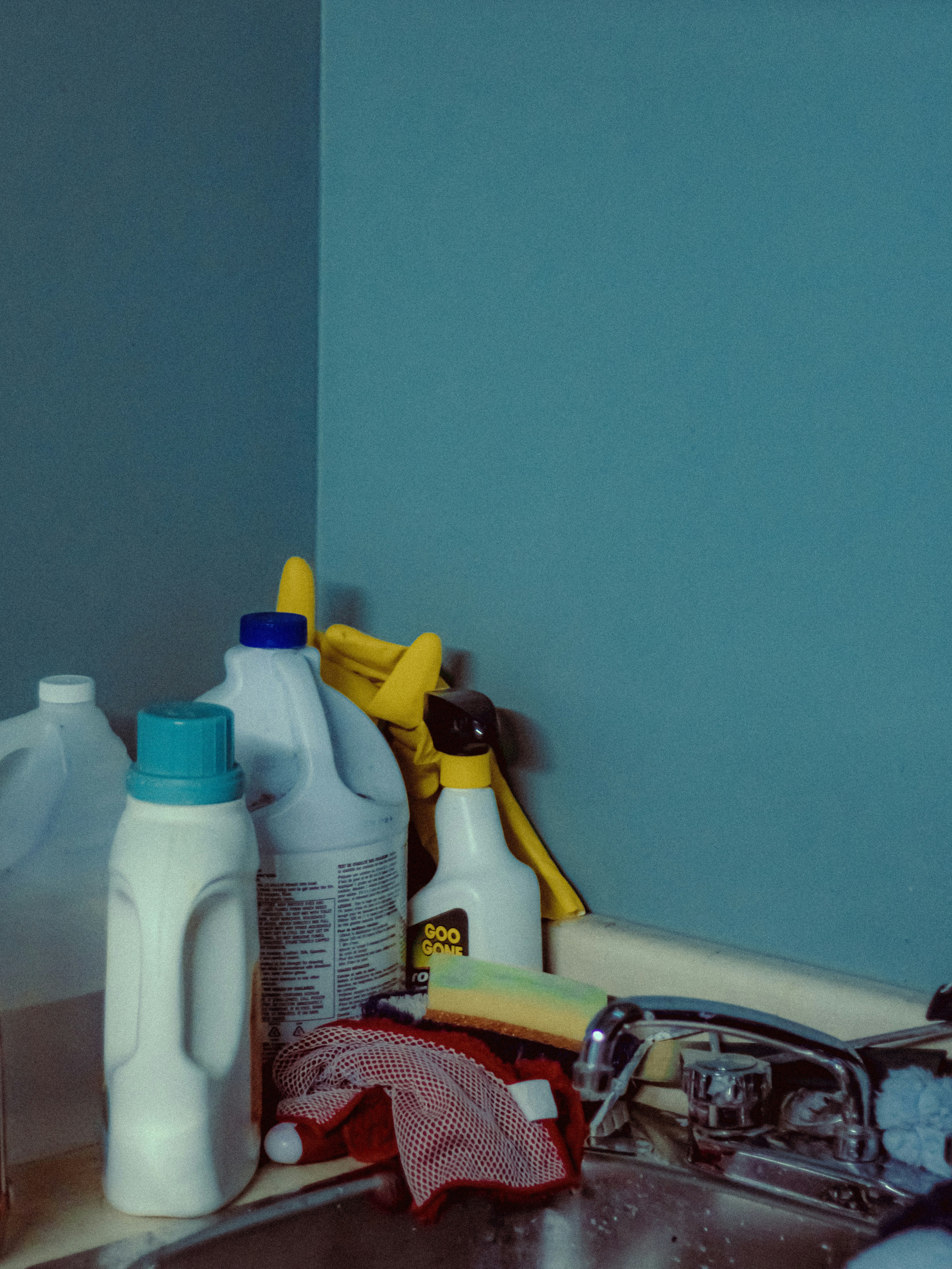 A sink with a bunch of cleaning supplies on it