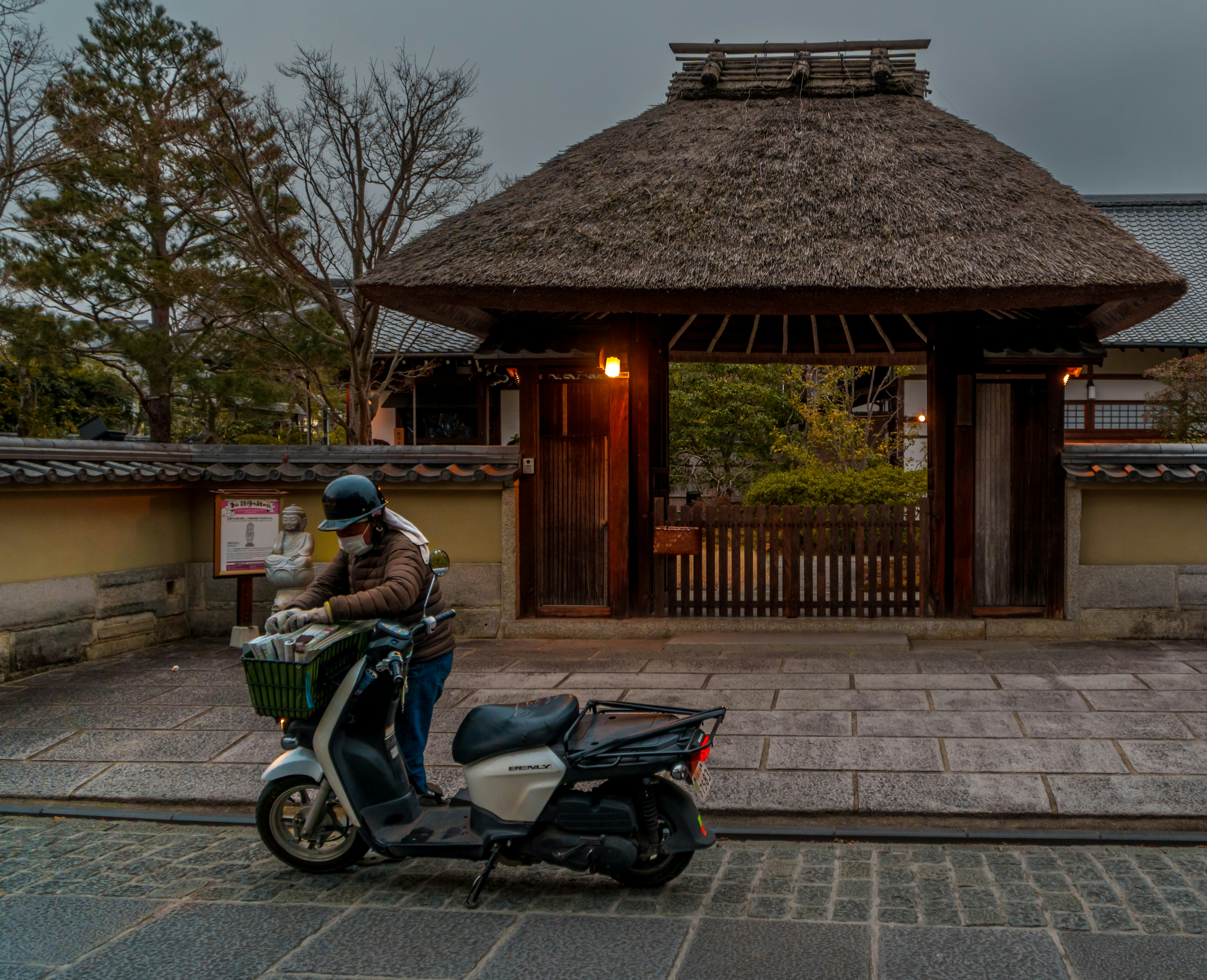 A person riding a scooter in front of a building