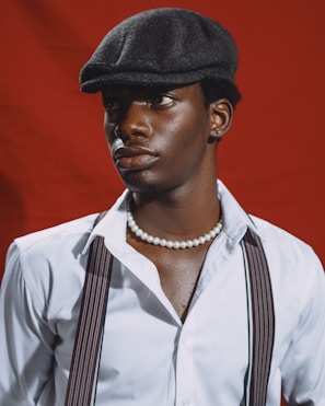 A man wearing a hat and suspenders