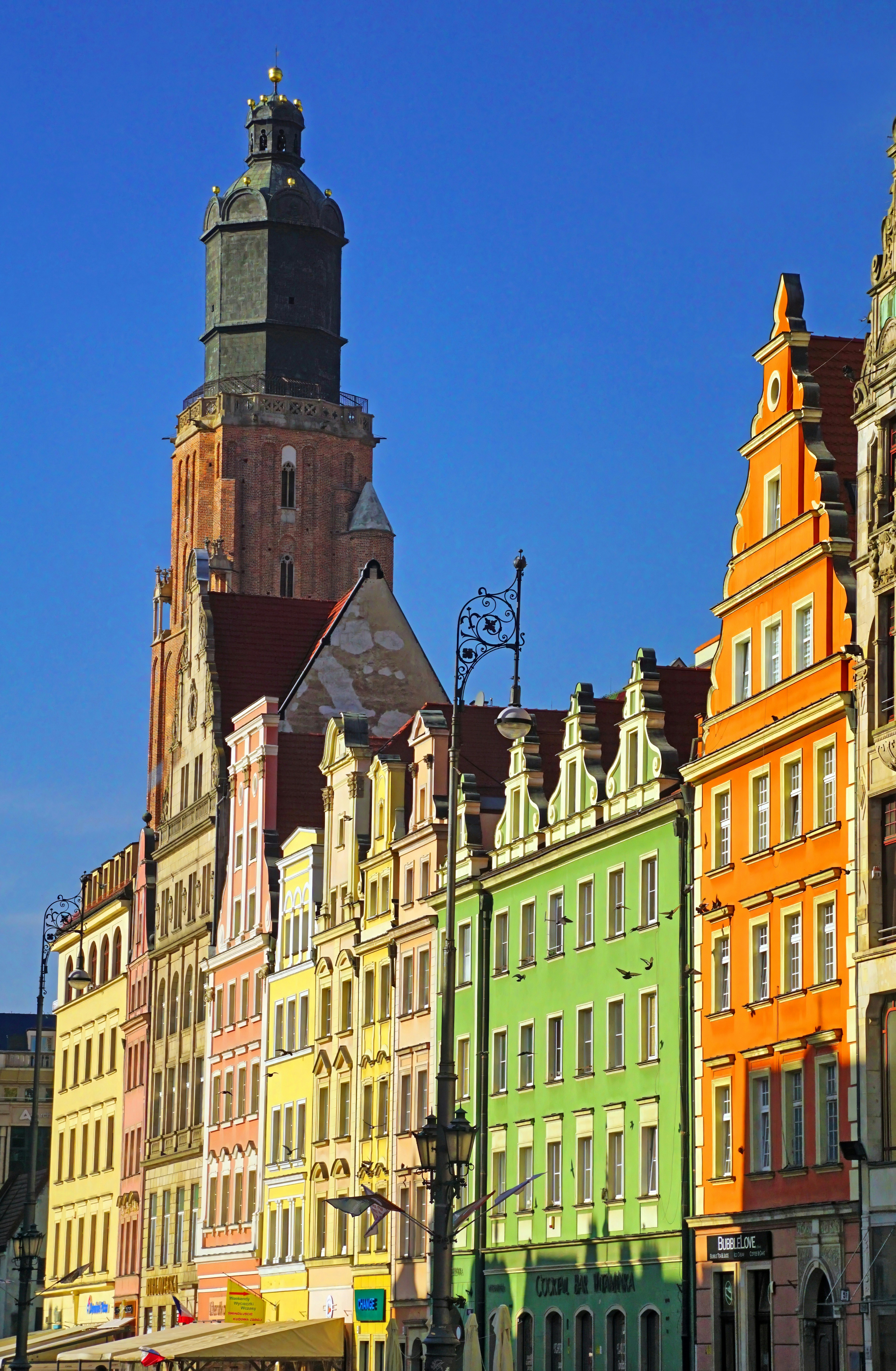 A row of buildings with a clock tower in the background