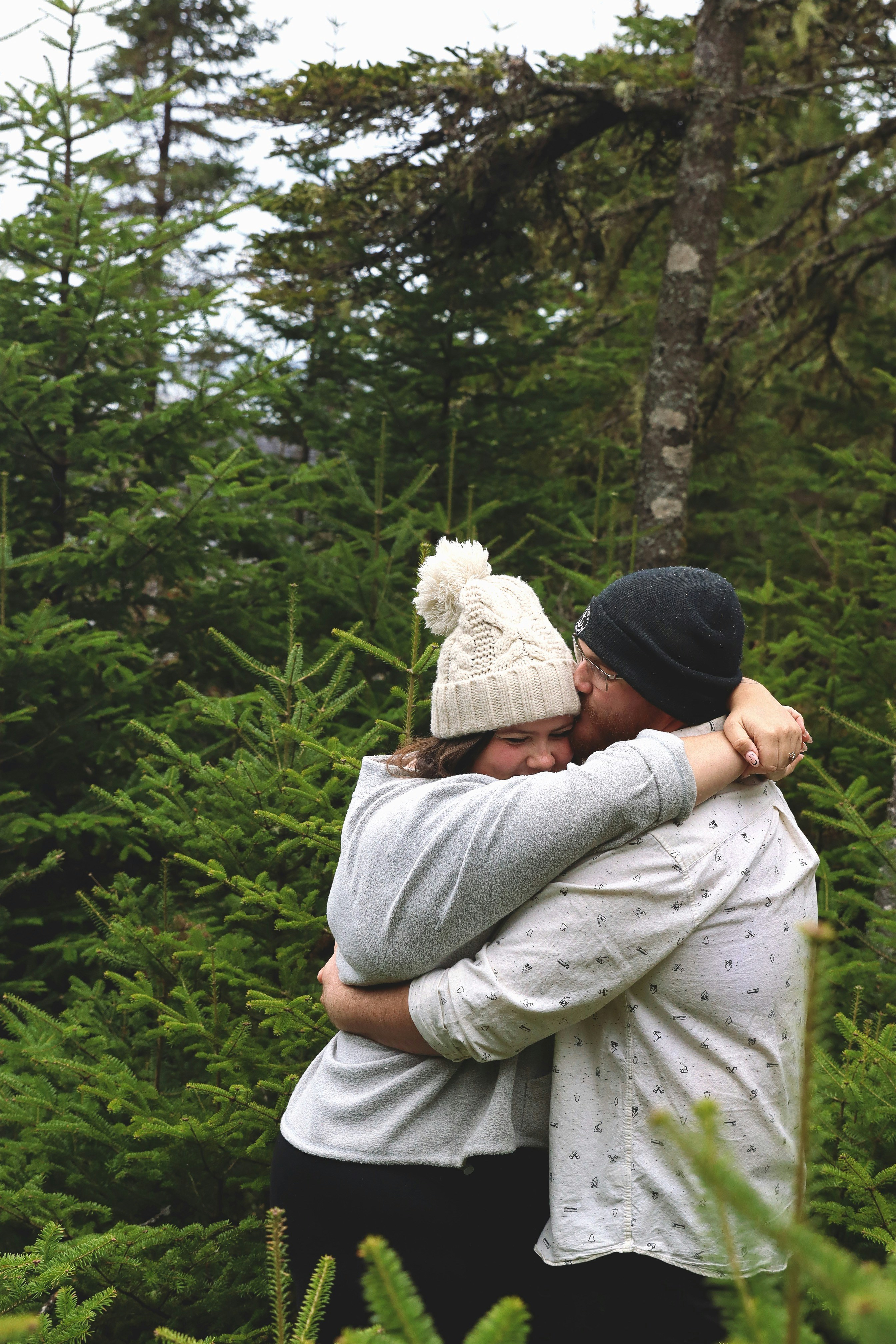 A man and a woman hugging in the woods