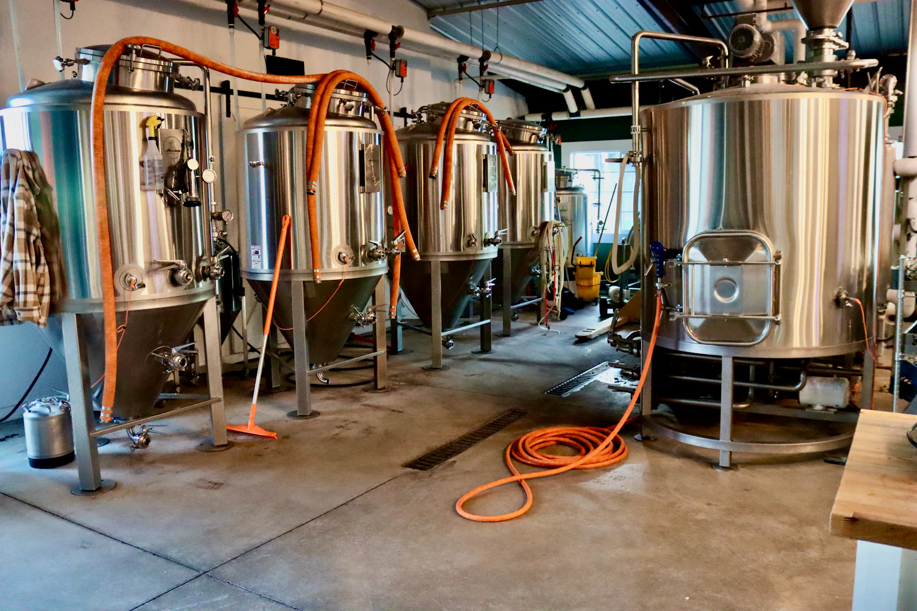 Industrial brewery tanks in a warehouse-like space