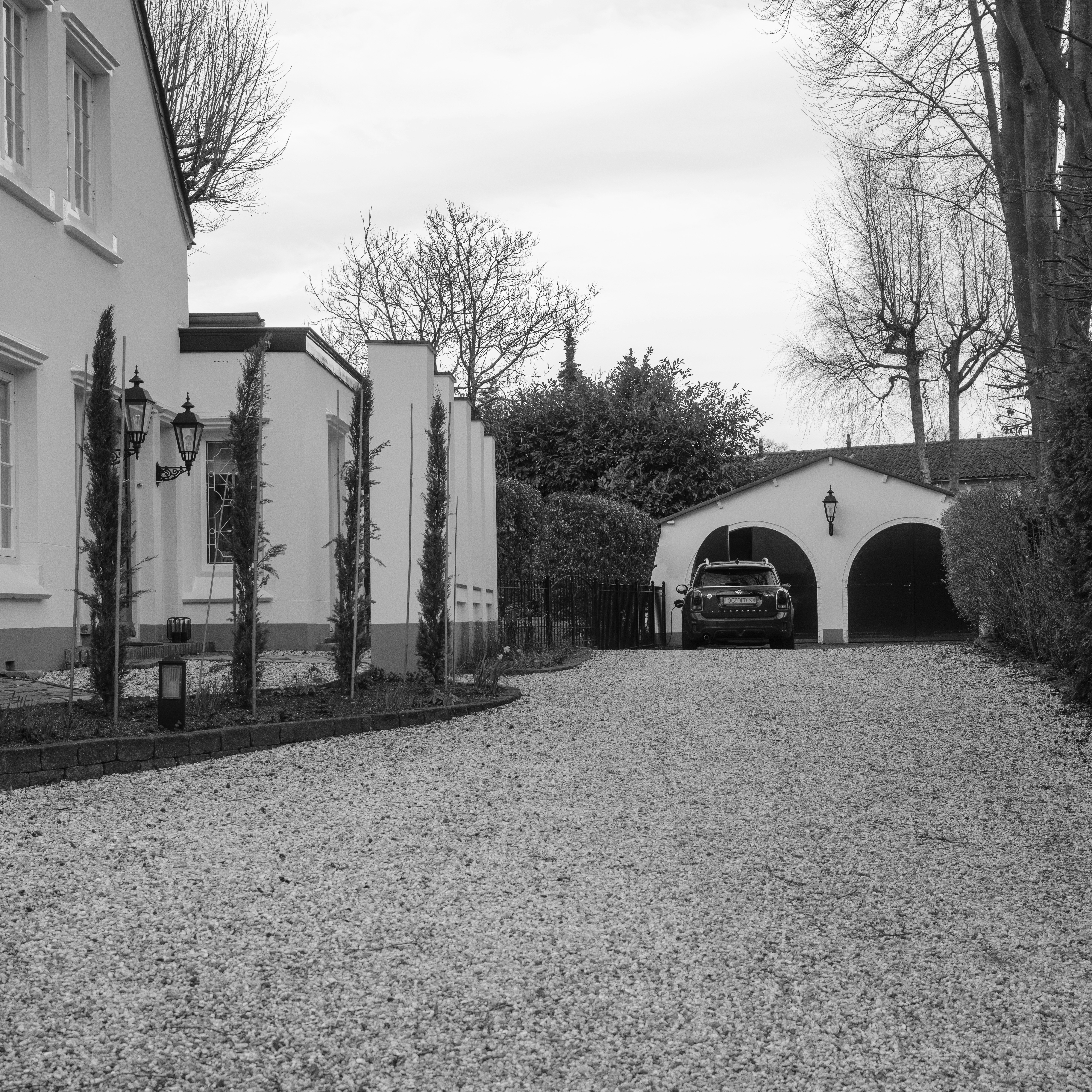 Aanleg van een oprit in kasseien met bijpassende voortuin.