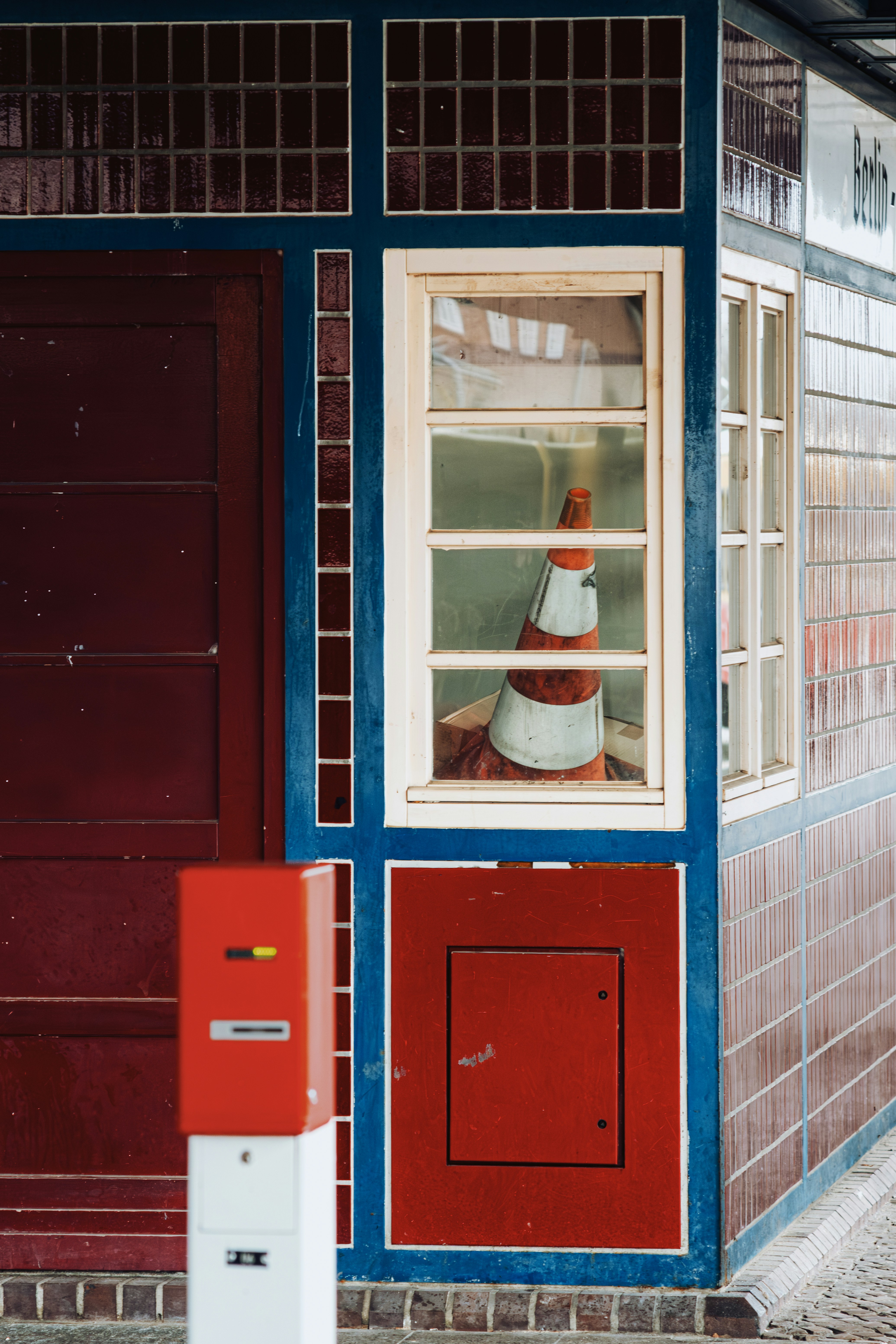A red and blue building with a red door and window photo – Free Germany ...