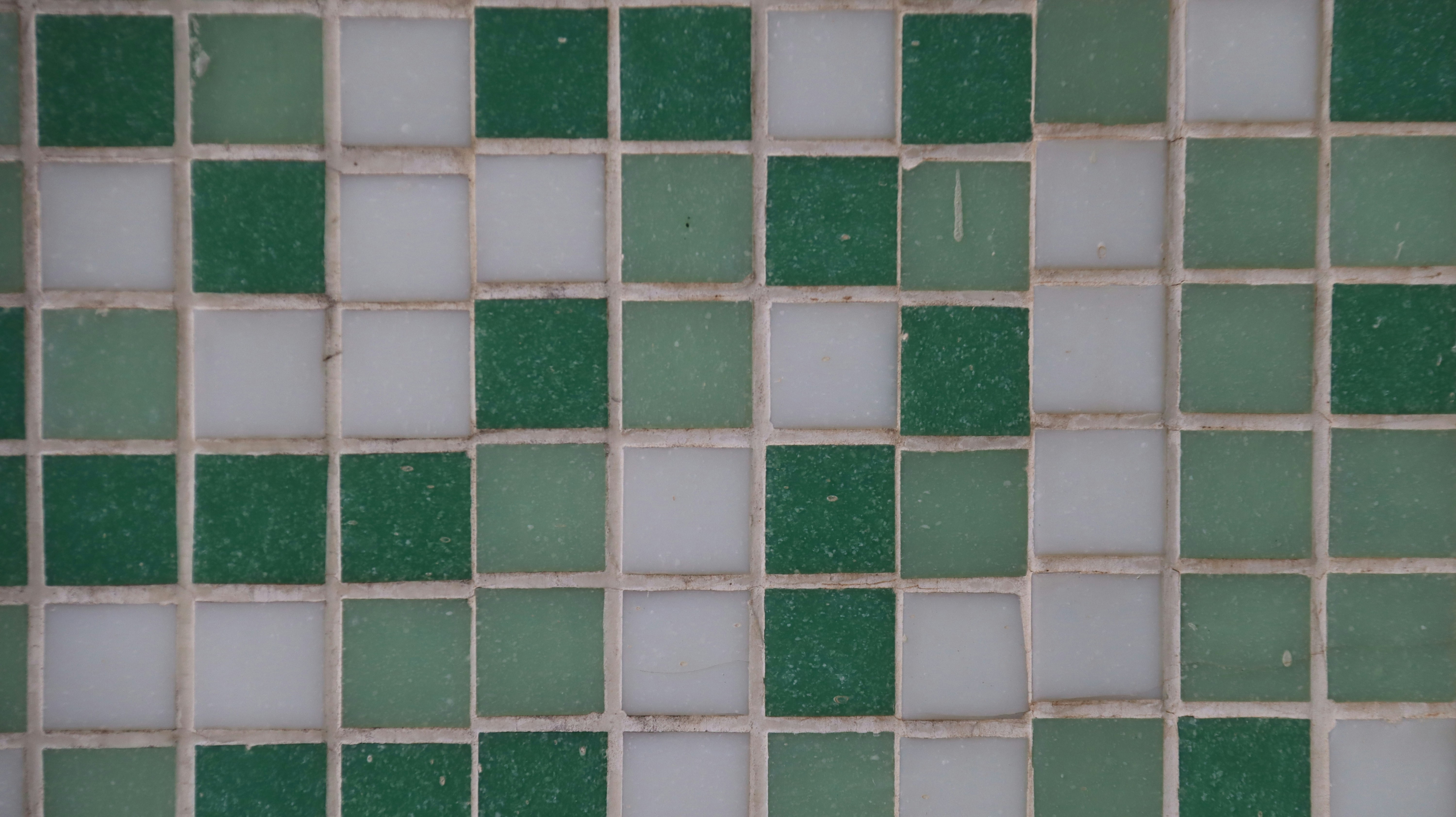 A close up of a green and white tiled wall