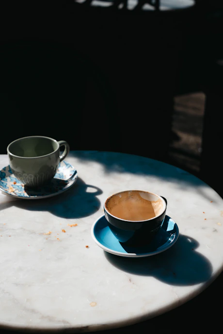 Two cups of coffee sitting on a table