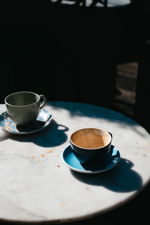 Two cups of coffee sitting on a table