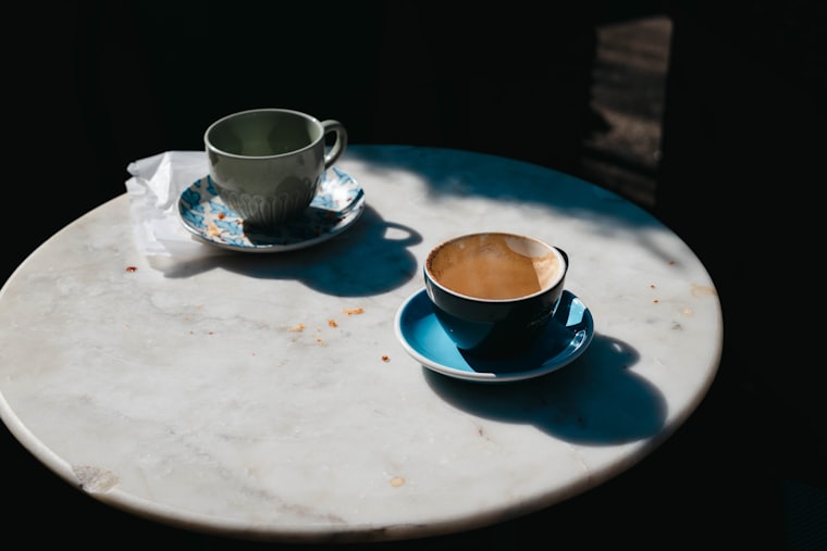 Deux tasses de café posées sur un guéridon en marbre