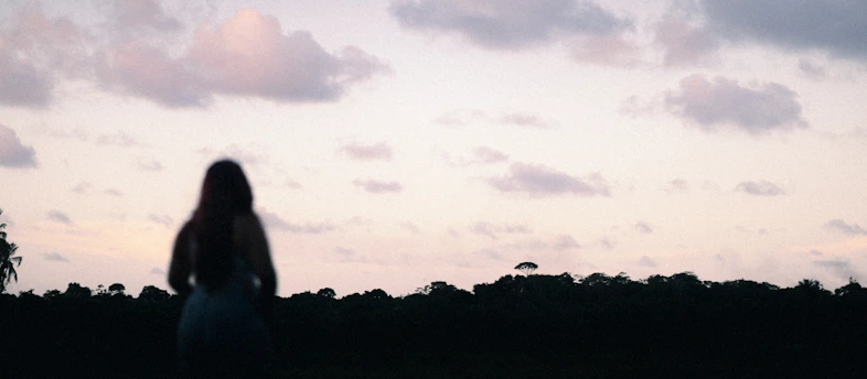 A blurry photo of a woman standing in a field