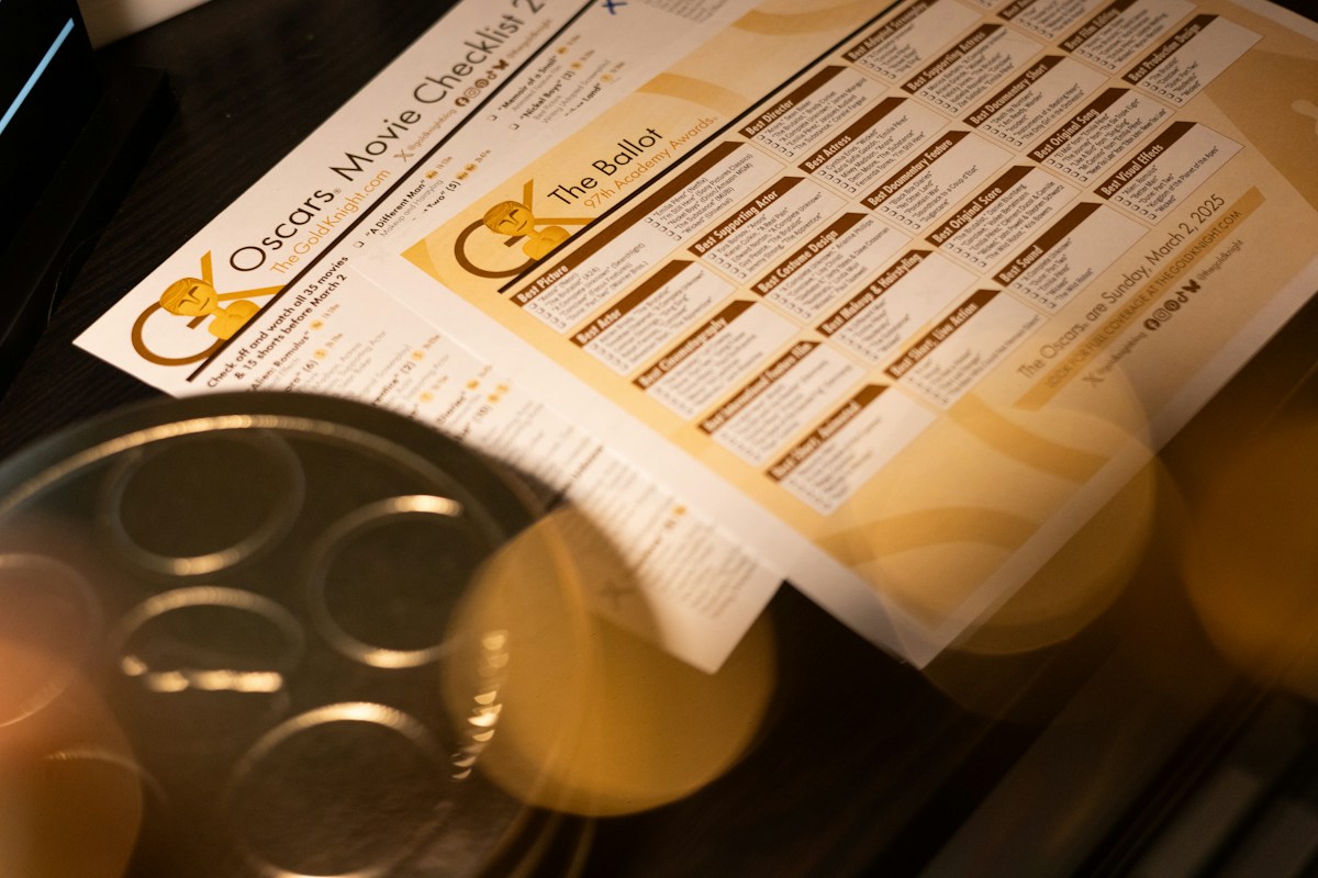 Cupcake pan with paper sign-up sheets for organizing swim team volunteers on a wooden table