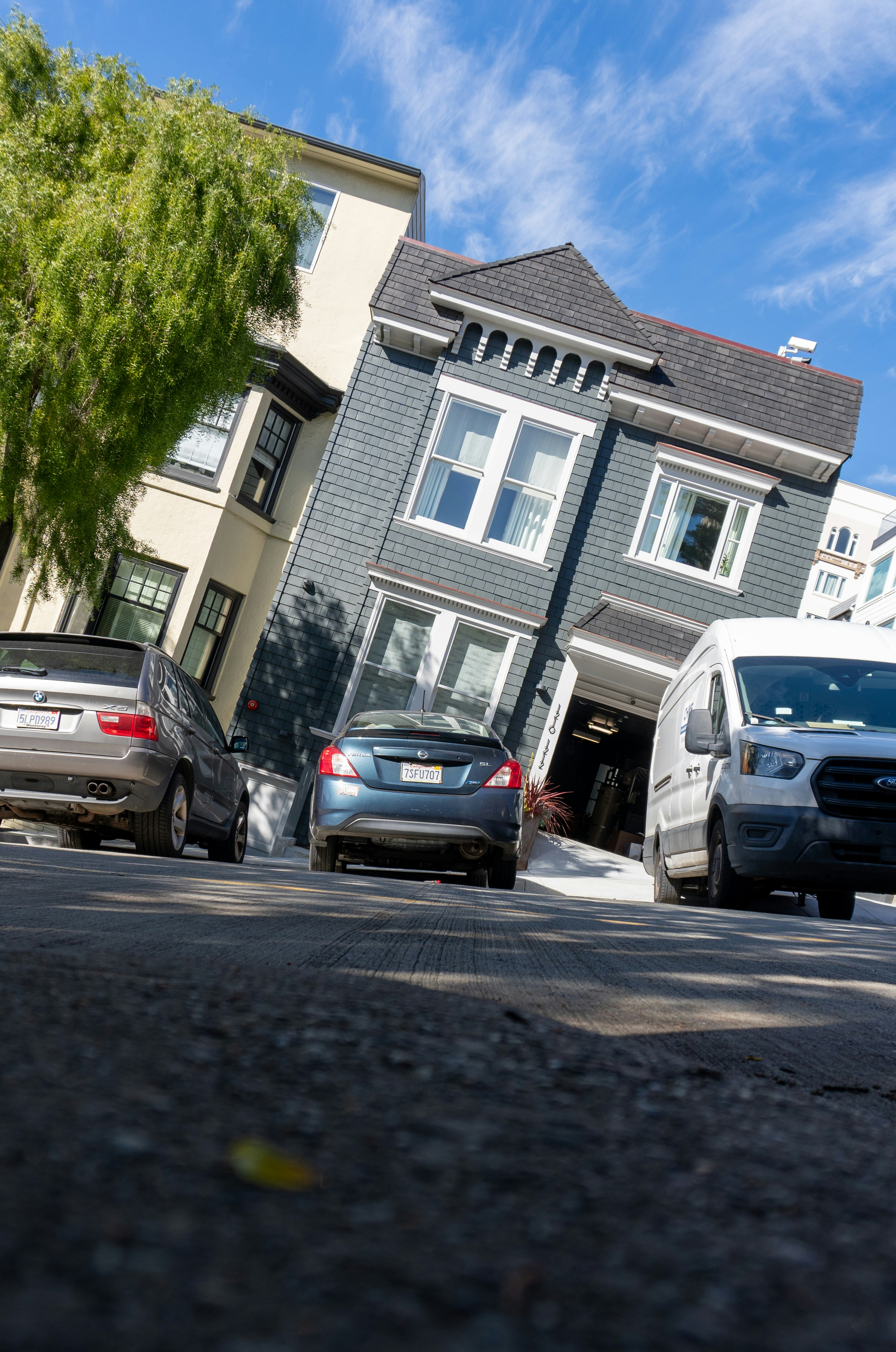 Cars parked on the side of the road in front of a row of houses