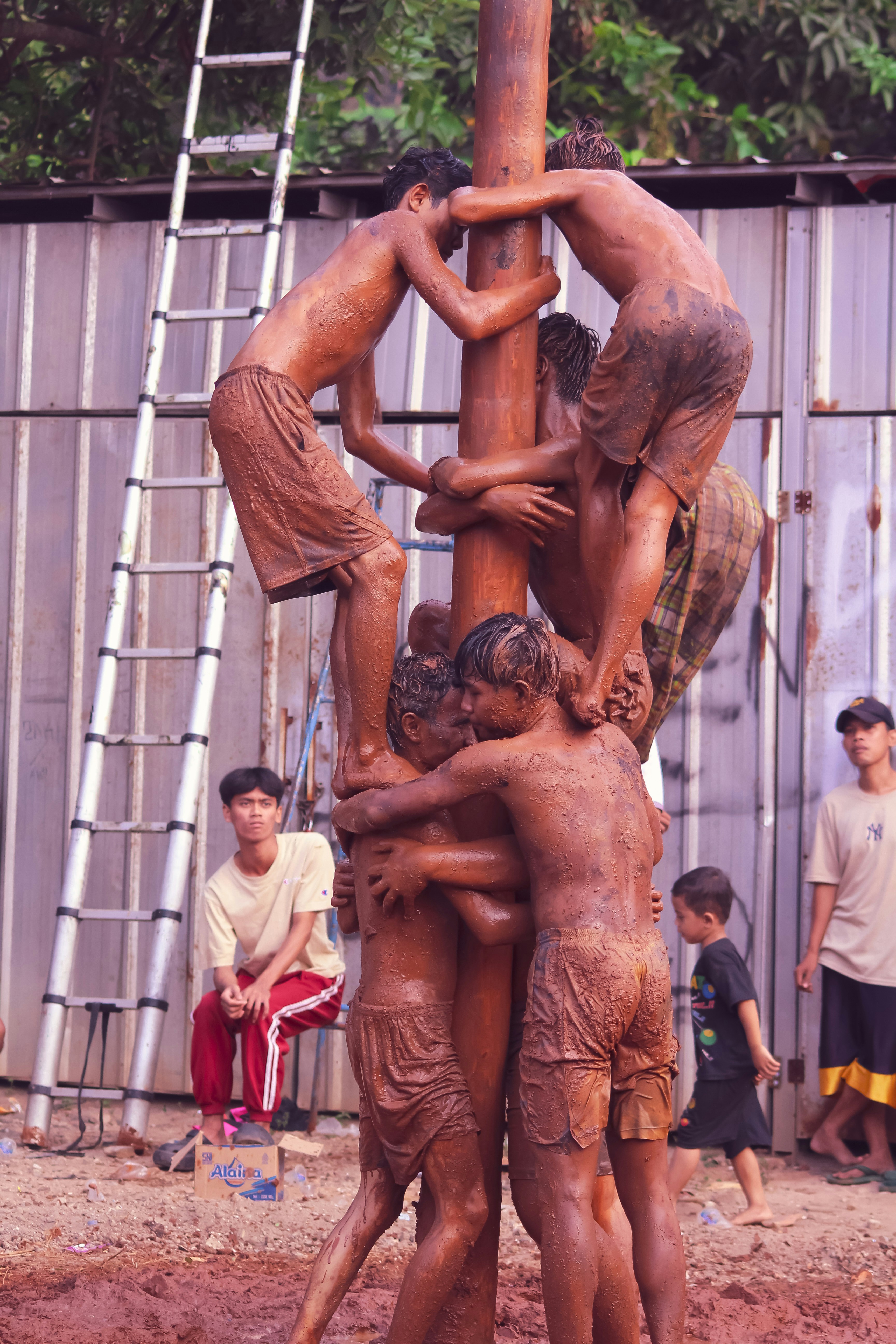 A group of people standing around a wooden pole